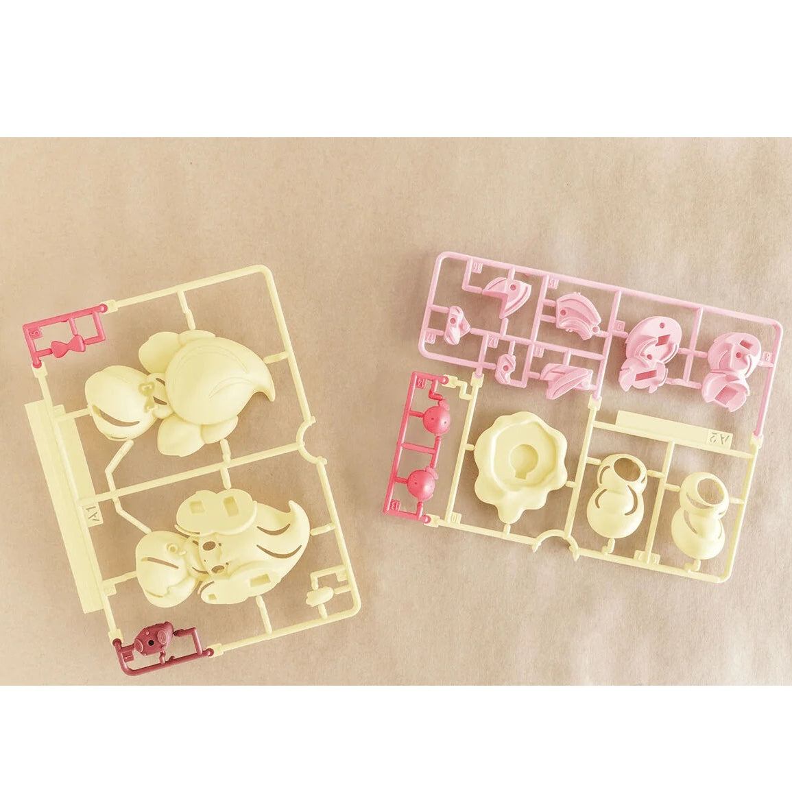 Two transparent plastic models with cartoon characters on a beige background