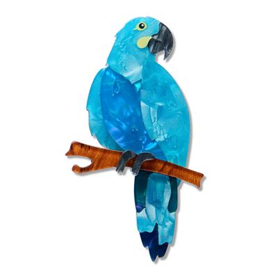 Blue parrot figurine perched on a branch against a white background