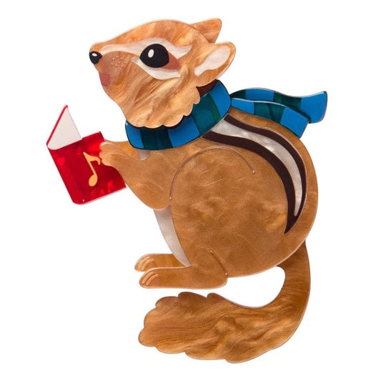 Erstwilder Brooch Chipmunk holding a red Christmas hymn book with a blue scarf on a white background