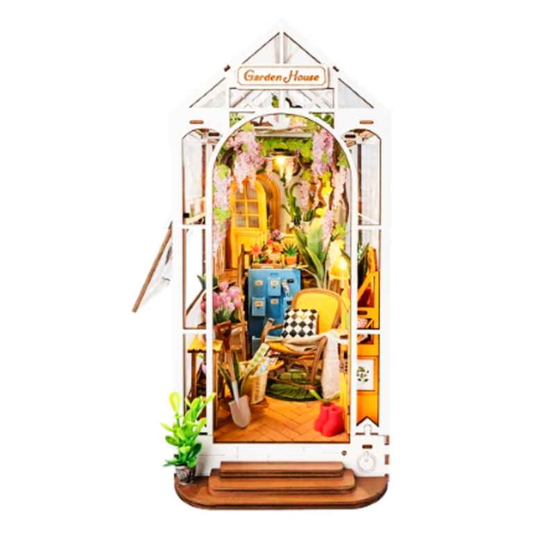 Miniature garden house model with interior details on a white background