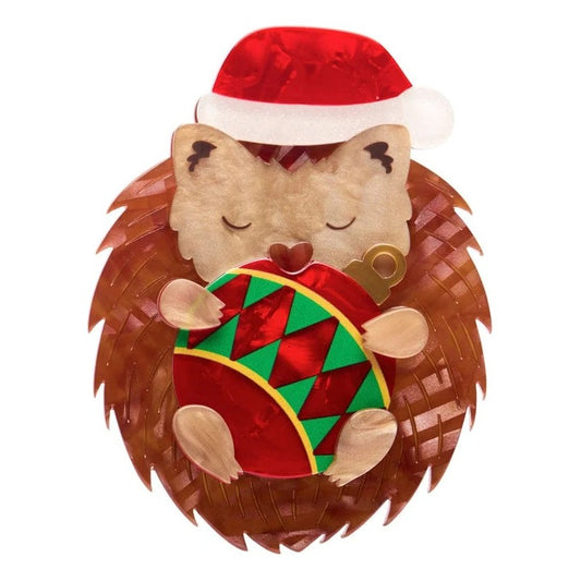 Hedgehog plush toy wearing a Santa hat with a Christmas ornament on a white background