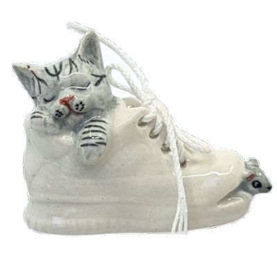 kitten asleep in  sand shoe with a mouse peeping out the to foot end