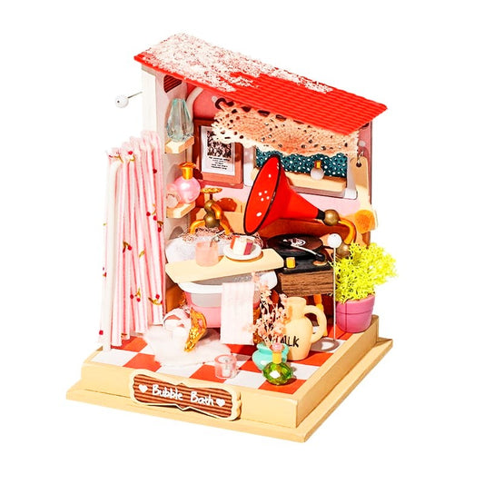 Miniature dollhouse with various items on a white background