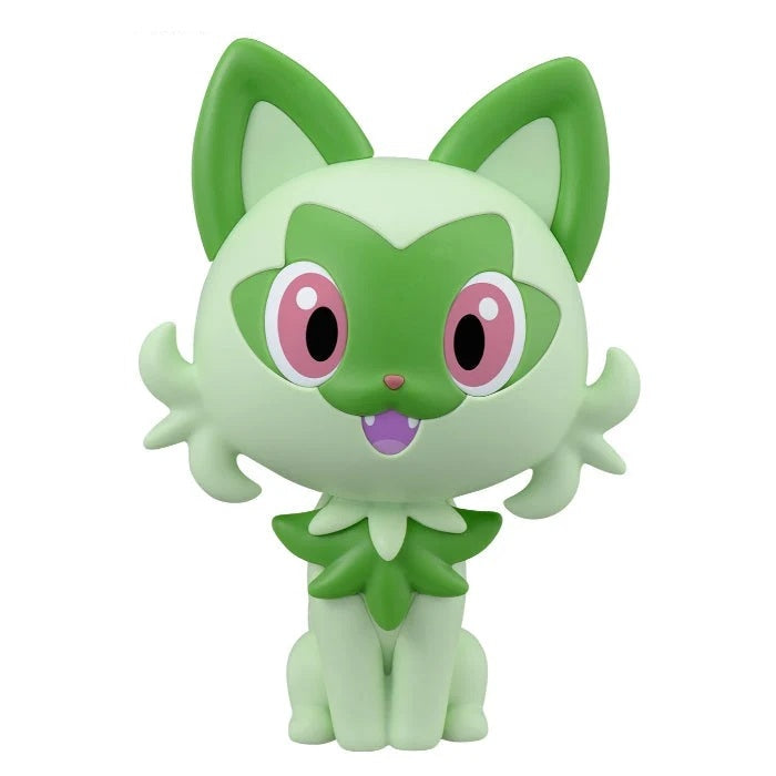 A green and light green cartoon cat figurine with large pink eyes and a small purple mouth, shown against a plain white background.