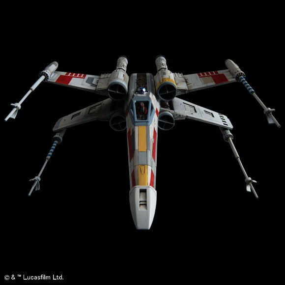 A detailed model or scale photo of a Star Wars X-wing TIE fighter, shown from a top-down perspective against a solid black background. The ship features its signature white, gray, red, and yellow paint scheme with attached weapons.
